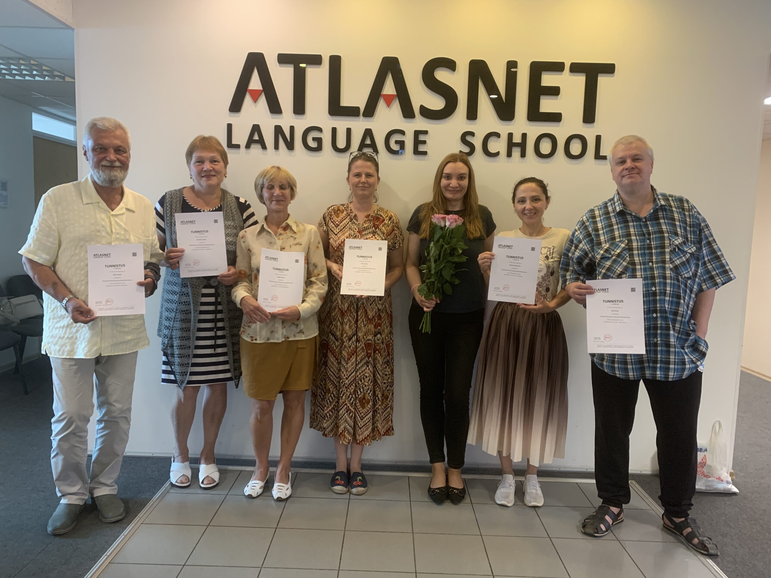 image00003 Выпускная группа курса эстонского языка уровня A2 в языковой школе ATLASNET, студенты держат сертификаты о завершении курса, учительница с цветами в центре